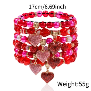 Close-up of multilayer red and pink beaded bracelets with sparkling heart charms