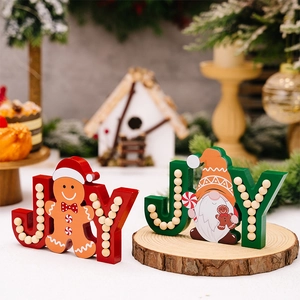 Close-up of JOY wooden Christmas ornaments with gingerbread and gnome holiday patterns