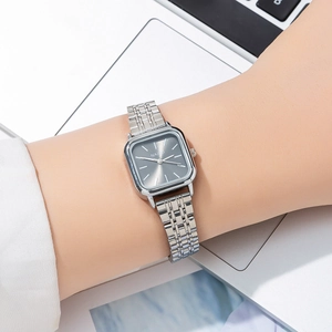 Close-up of a silver square lady's watch with dark grey dial on a person's wrist