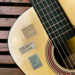 Dettaglio di adesivi vintage con citazioni di Shakespeare su una chitarra per decorazione