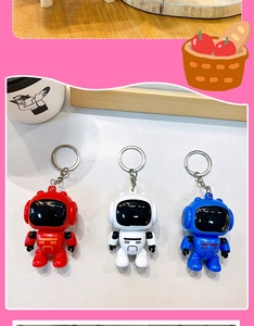 Detail view of three cartoon astronaut robot keychains in red, white and blue colors