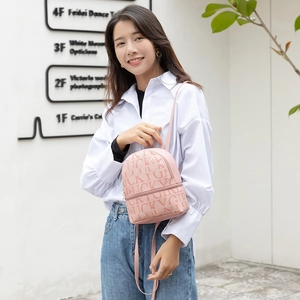 Pink mini faux leather backpack with LUCKY print and zipper closure on a fashion model
