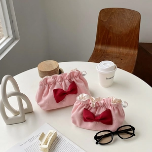 Detail shot of pink quilted cosmetic bags with red bows and crystal zipper charms