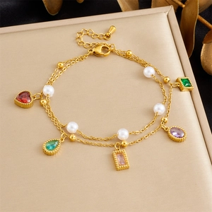 Detail van de goudkleurige dubbellaagse armband met gekleurde edelstenen en parels