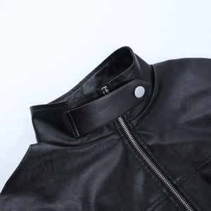 Detail of the stand-up collar and metallic zipper on a black faux leather jacket