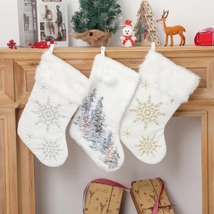 White plush Christmas stockings with embroidered snowflake and tree patterns on a mantel