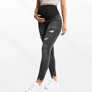 Detailed view of grey maternity jeans with ripped knees and elastic high waist support