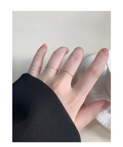 Detailed view of three textured S925 sterling silver minimalist 1mm rings on female fingers