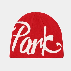 Detail of red knit beanie featuring thick wool texture and white Park script embroidery
