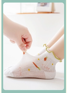 Detail of breathable white mesh socks with carrot pattern and green lettuce trim for kids