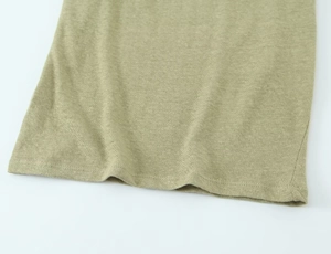 Detail of olive green linen blend knitted T-shirt hem with textured fabric and clean stitching