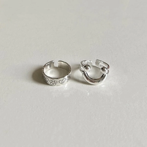 Macro detail of S925 sterling silver rings showing engraved smile face and heart patterns