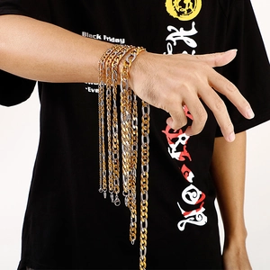 Detail of 18K gold and silver stainless steel curb chain on model wrist and neck