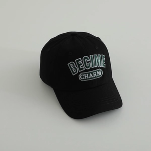 Close-up of BECIME CHARM letter embroidery on a black cotton baseball cap