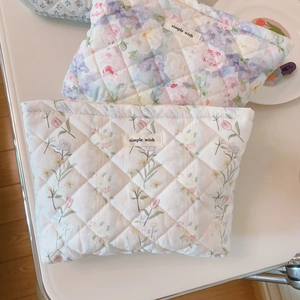 Detail of floral quilted cotton makeup bags with zipper closure and smooth texture