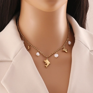 Detail of bohemian gold-plated double chain necklace with shell charms and pearls on model