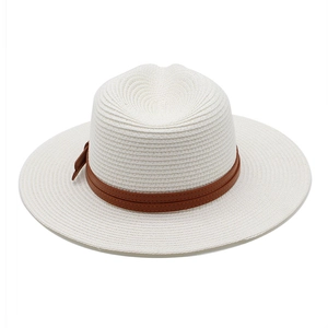 Détail du tissage de paille blanche et ruban en cuir marron avec petit nœud décoratif