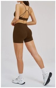 Detail of cross-back yoga bra and high-waist shorts in matte chocolate brown fabric