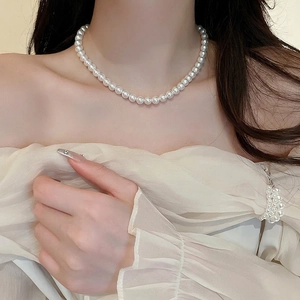 Elegant French style pearl necklace with white round beads for women on an Asian model