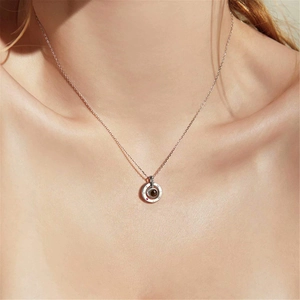 Close-up of projection stone necklace with Roman numerals worn by model showing pendant size