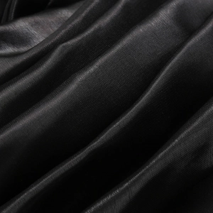 Close-up of premium black satin fabric texture with elegant folds and silky finish