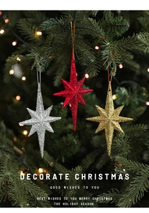 Close-up of glittery red, gold, and silver octagonal star ornaments on a Christmas tree