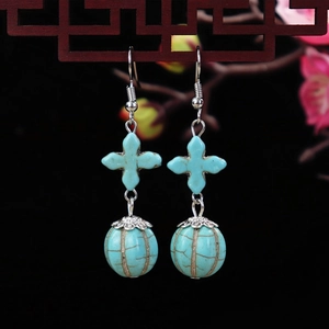 Detail of vintage ethnic turquoise earrings with flower motifs and water drop turquoise beads