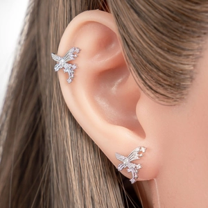Silver butterfly earrings with rhinestones on a model ear made of titanium steel