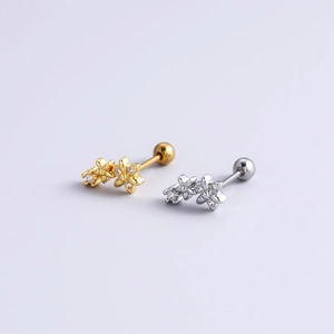 Macro detail of gold and silver flower stud earrings with sparkling zircon crystals