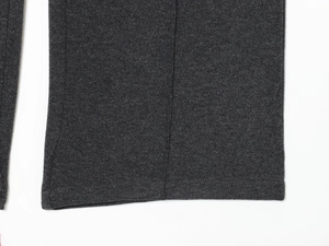 Detailansicht der Saumnaht und der weichen Stricktextur der dunkelgrauen Hose mit weitem Bein