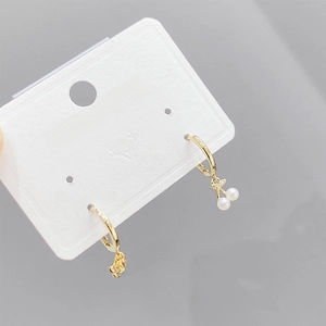 Gold star and cherry pearl charm earrings set on a white fashion jewelry display card
