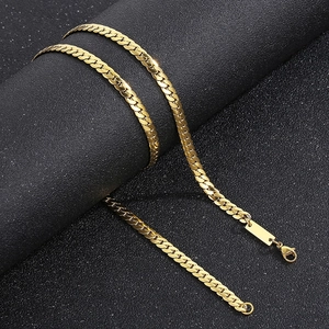 Macro detail of 18K gold plated curb chain necklace with a polished engravable metal tag