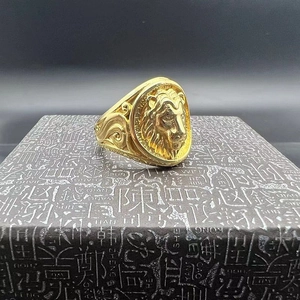 Macro detail of golden lion head ring with embossed textures on a square jewelry box