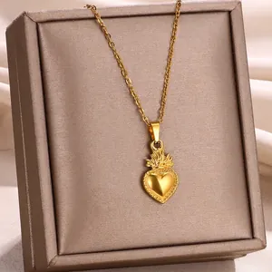 Detail of 18k gold heart pendant necklace with dotted edges on a brown jewelry box