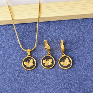 Golden butterfly necklace and earrings set with black round pendants on blue background
