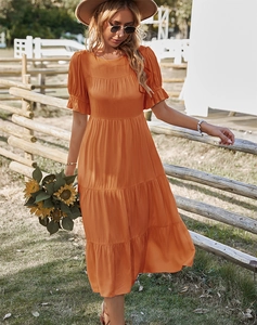 Détail de la manche à volants et de la jupe à plusieurs niveaux sur cette robe orange