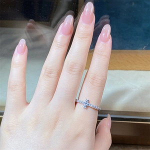 Close-up of elegant V-shaped 925 silver ring with zircon cross detail on model finger