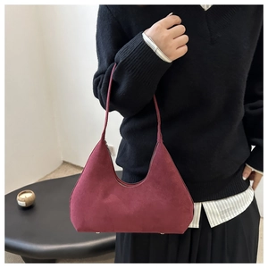 Detailed view of burgundy suede hobo bag with minimalist design and zipper closure