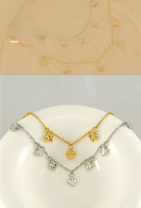 Macro detail of textured heart pendants on gold and silver stainless steel necklaces