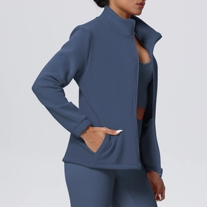 Detail view of the high-stretch knitted fabric and functional side pocket on blue yoga jacket