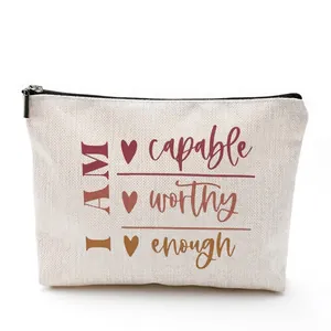 Canvas makeup bag with motivational quote and black zipper on white background