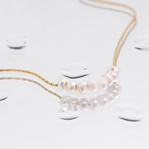 Minimalist 18k gold plated necklace featuring seven natural white freshwater pearls