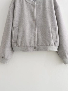Détail de veste en laine gris clair avec boutons-pression en métal et bords-côtes sur blanc