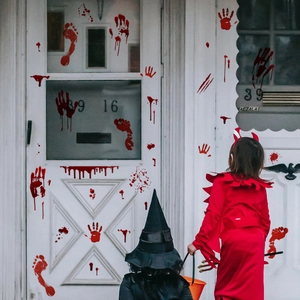 Close-up of Halloween bloody handprint and footprint decals on a white door