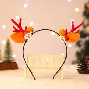 Cerchietto con corna di renna natalizie con Babbo Natale e pompon su panca bianca