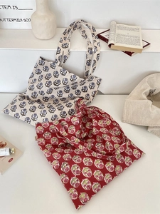 Floral canvas tote bags in blue and red patterns displayed on minimalist white stairs
