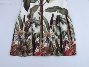 Detail of tropical palm leaf print on white fabric with natural pleats and drape