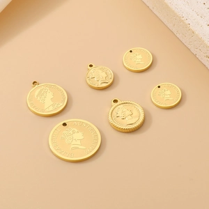 Golden stainless steel Elizabeth II coin charms displayed on a textured stone background