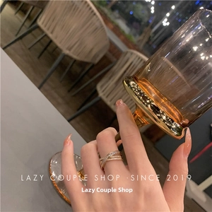 Close-up of a gold criss-cross ring with pavé sparkling crystals on a hand