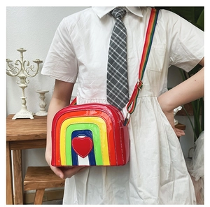 Detail of rainbow crossbody bag featuring glossy patent leather and red heart patch